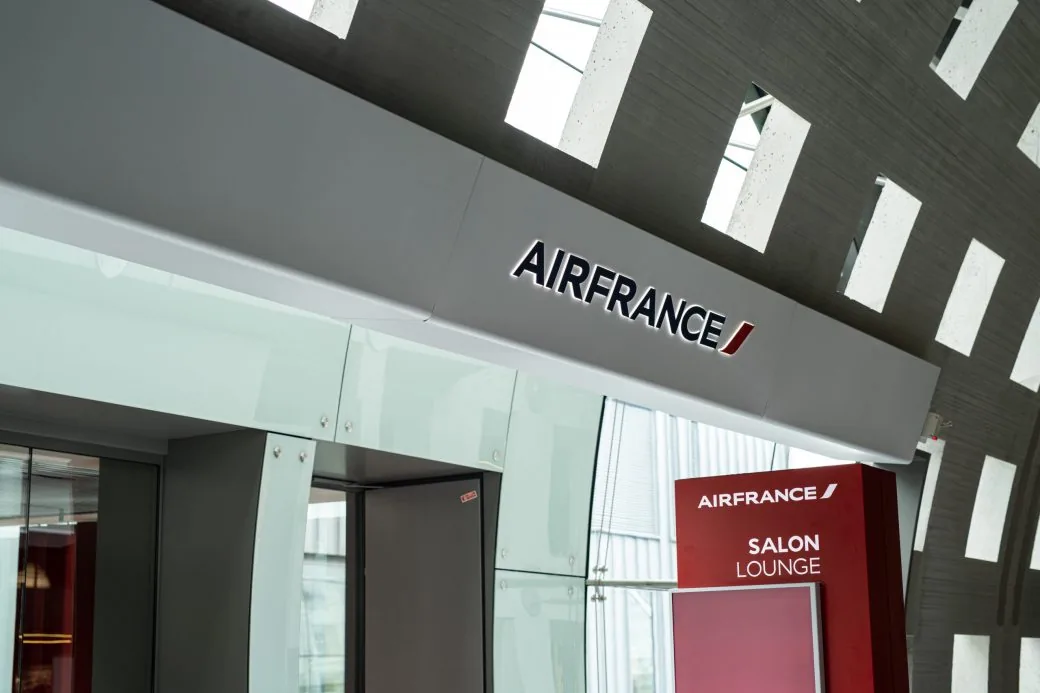 An Air France lounge entrance with an illuminated Air France sign and a Salon Lounge sign panel.