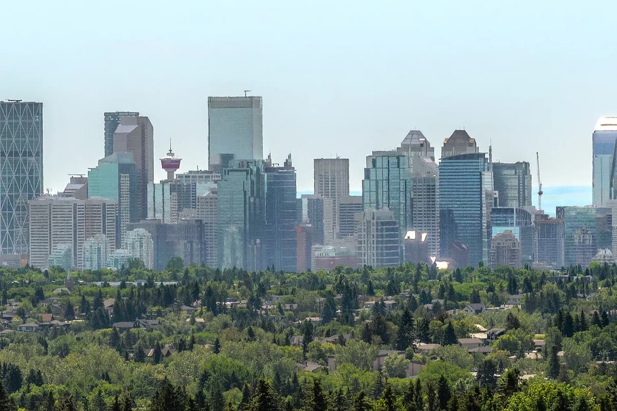 The Calgary skyline from the north west, downtown towers rising above the trees.