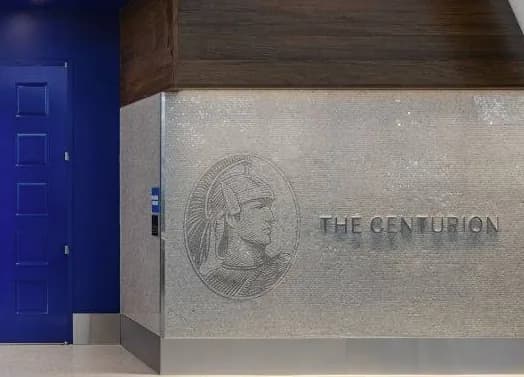 A wall sign reading The Centurion with an engraved emblem beside a blue door.